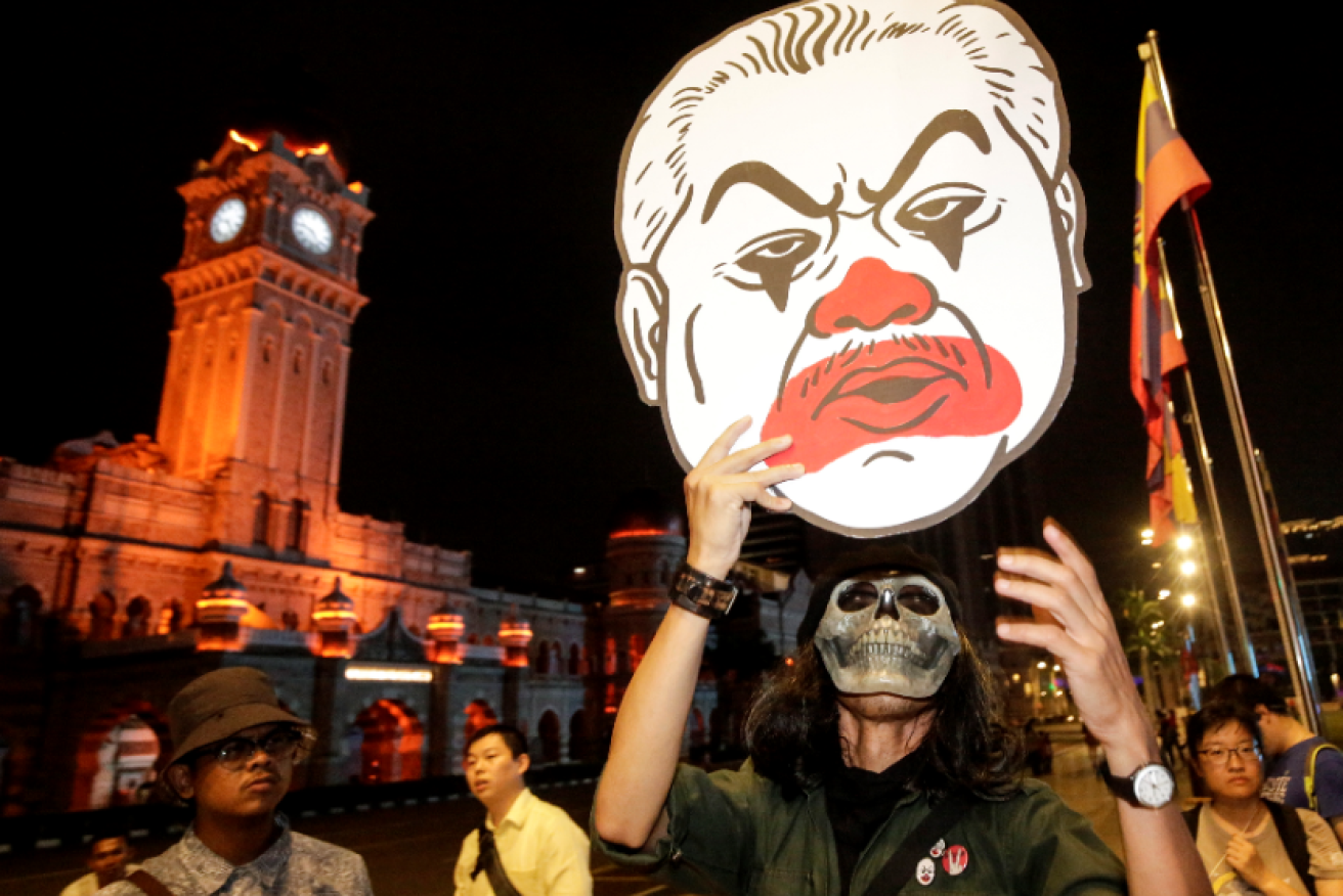A masked protestor ridicules newly-appointed Malaysian PM Muhyiddin Yassin as a dangerous clown.