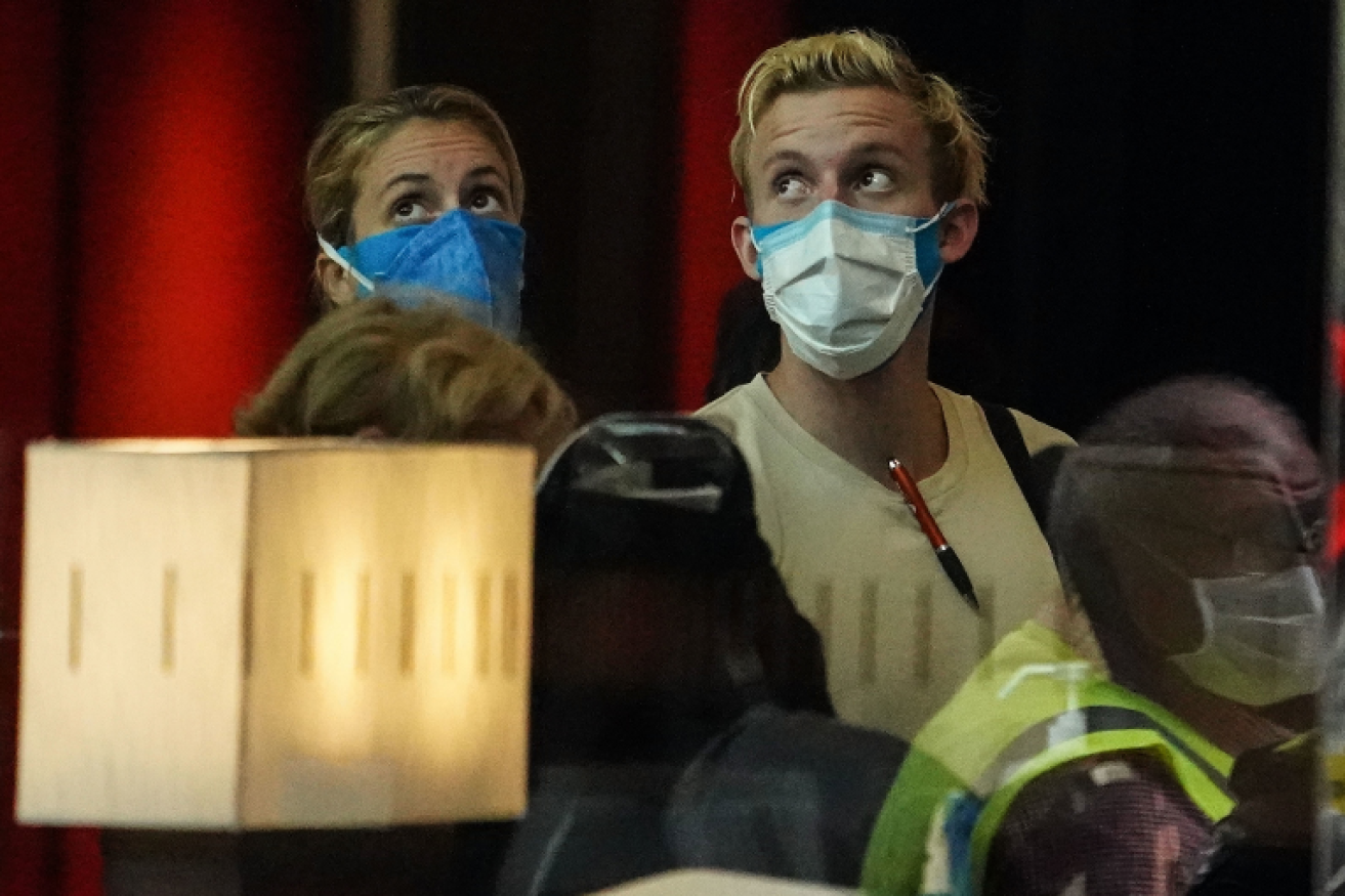 Off the plane and straight into quarantine, these travellers arrive at Melbourne's Crown Promenade Hotel.