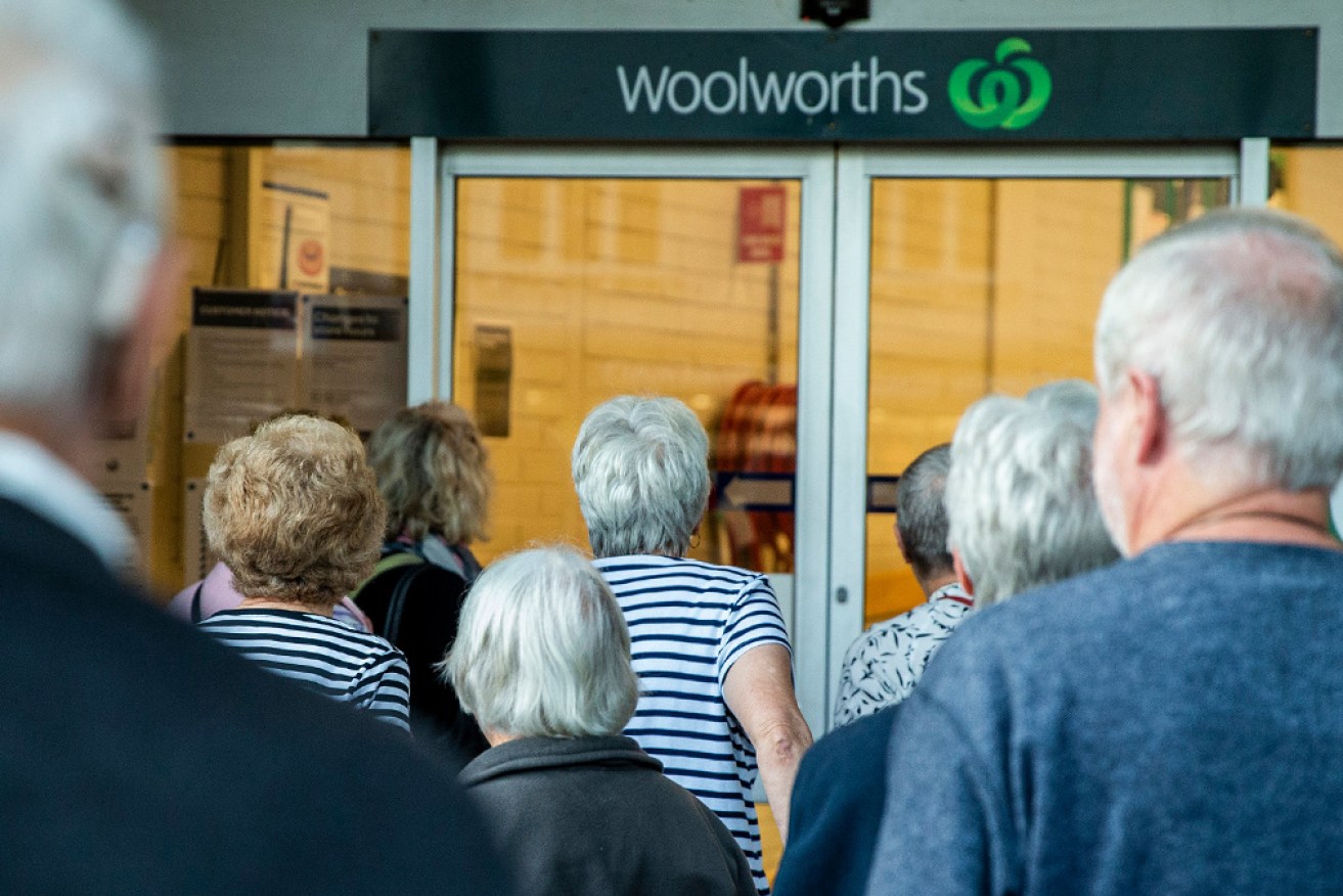 Shoppers wait for a suburban Woolworths to open.