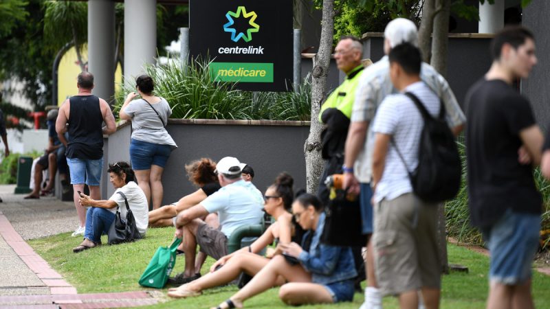 People are seen in long queues outside the Centrelink office in Southport on the Gold Coast, Monday, March 23, 2020. Centrelink offices around Australia have been inundated with people attempting to register for JobSeeker.