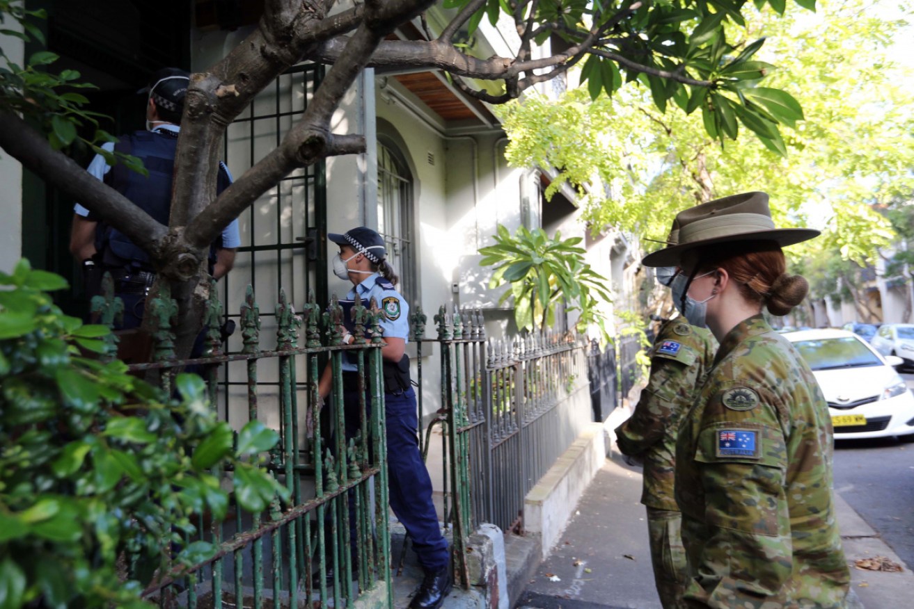 Police and ADF personnel conduct home checks under coronavirus laws.