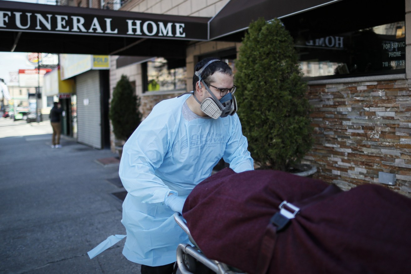 Employees deliver a body while wearing personal protective equipment at Daniel J. Schaefer Funeral Home in the Brooklyn borough of New York.