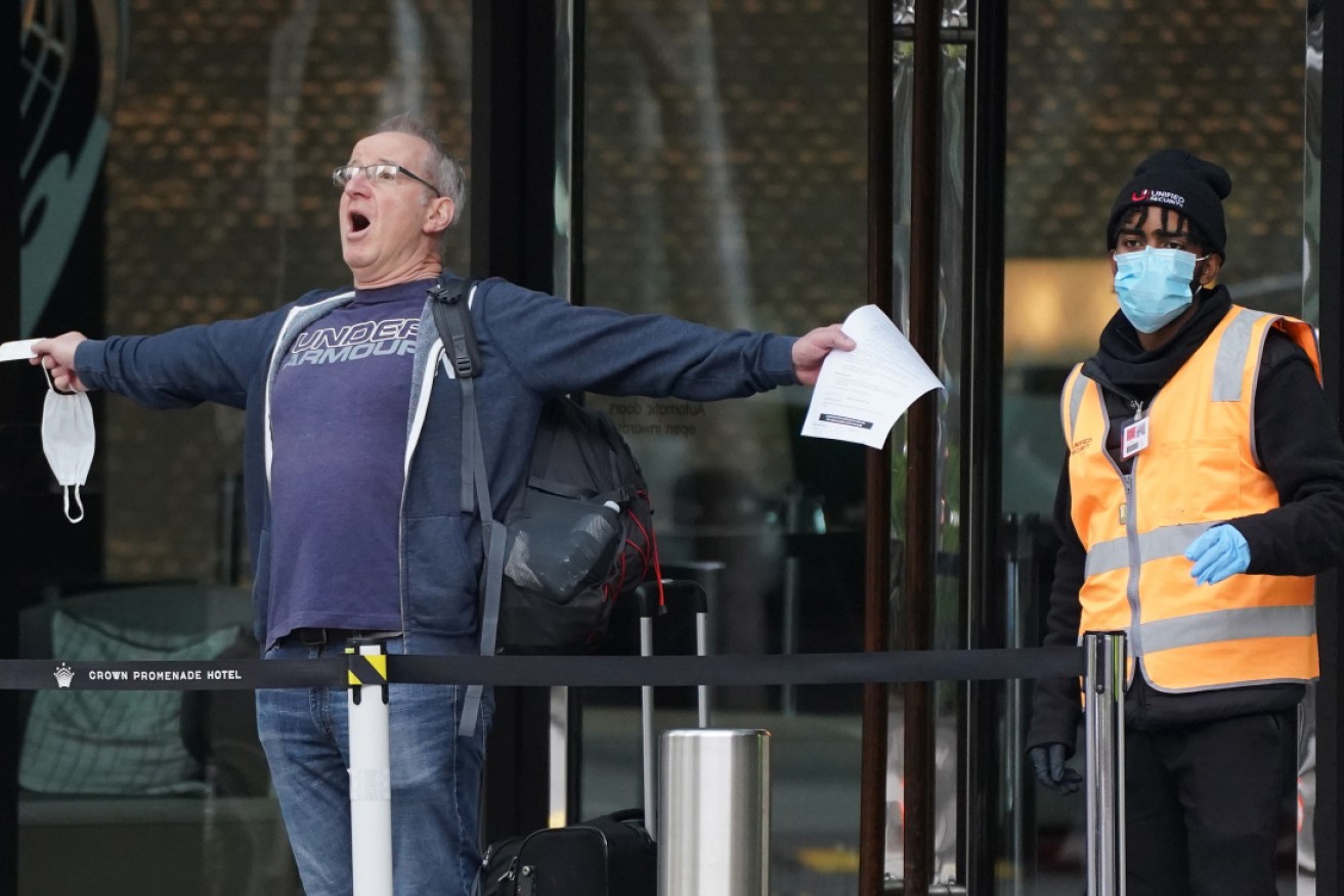 A man reacts as he leaves the Crown Promenade Hotel after spending two weeks in forced quarantine in Melbourne.
