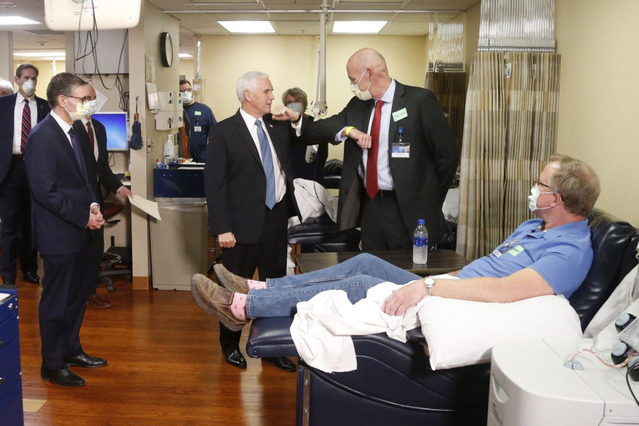 Vice-President Mike Pence, centre, visits with Dennis Nelson, right, who survived the coronavirus, at the Mayo Clinic in Minnesota.