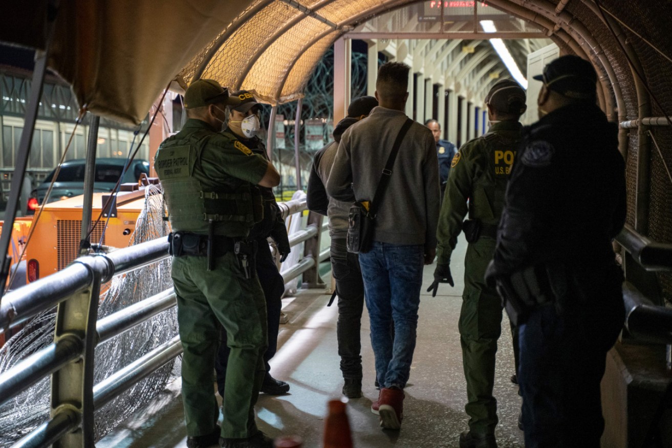 US Border Control officers with asylum seekers after immigration courts closed due the coronavirus pandemic.