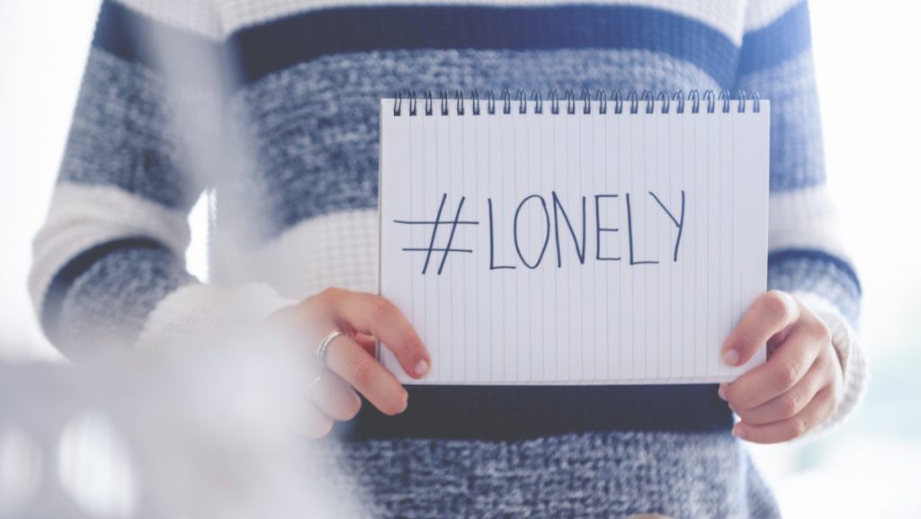 Woman holding a #lonely sign. This is to illustrate the loneliness of the Coronavirus stay at home order.