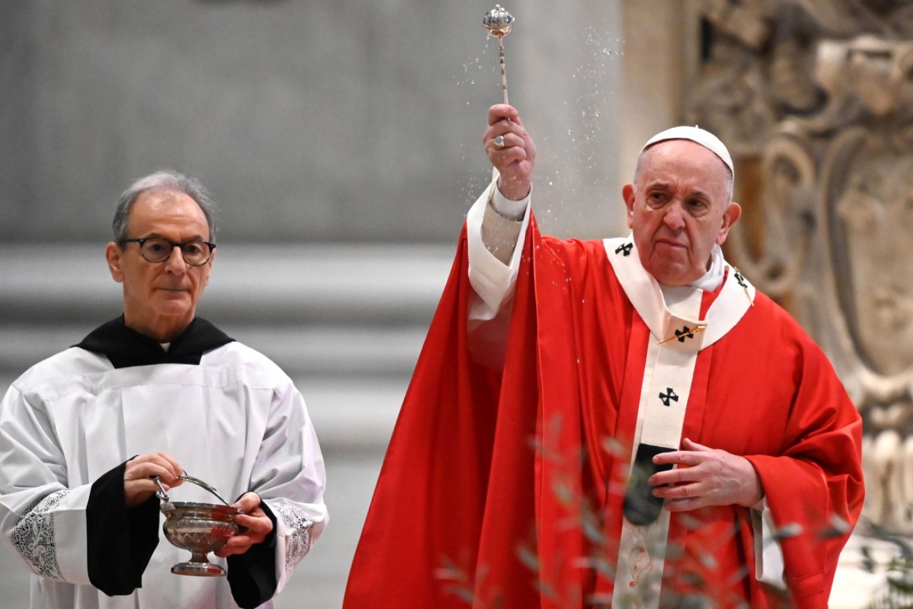 Pope Francis blesses attendees as he celebrates Palm Sunday mass behind closed doors in St Peter's Basilica, Vatican.