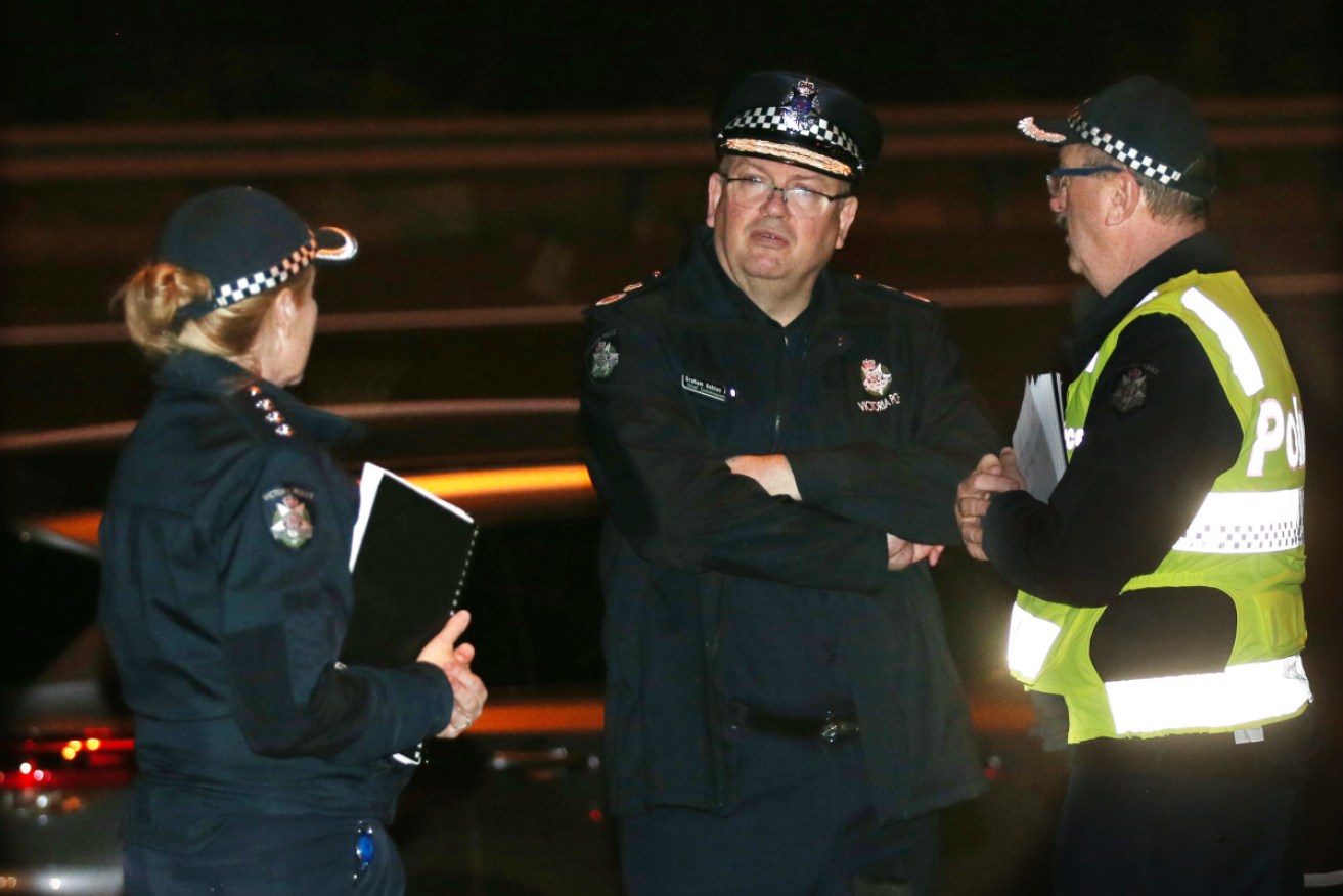 Victoria Police Chief Commissioner Graham Ashton (centre) near the scene of the deadly Eastern Freeway crash on Wednesday.