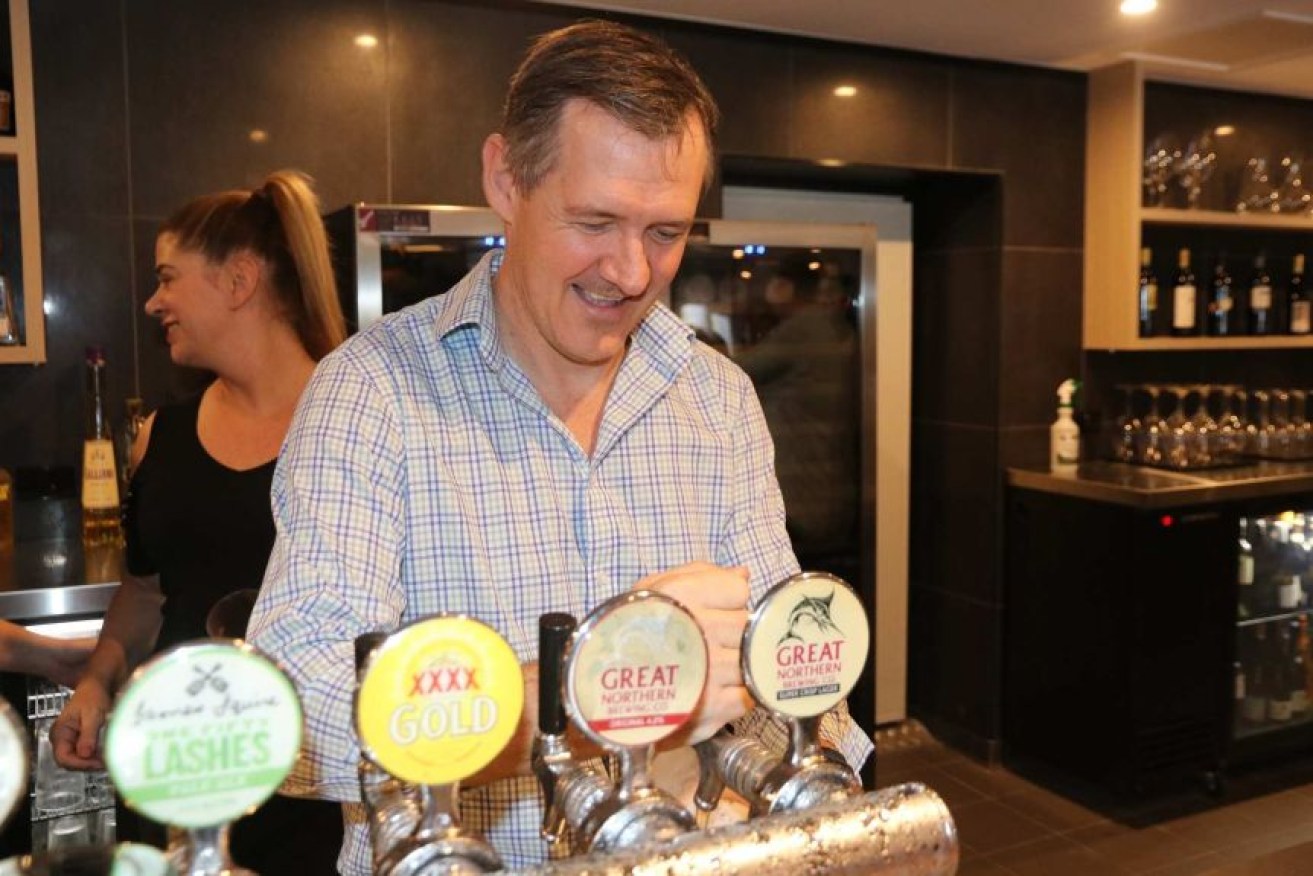 The NT's chief minister, Michael Gunner, pours a beer as pubs reopen in Darwin on Friday.