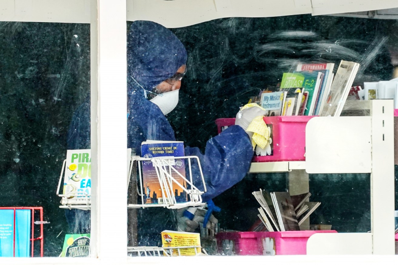 Still a danger: A cleaner inside Meadowglen Primary School in Melbourne, which was shut down after a coronavirus scare.  