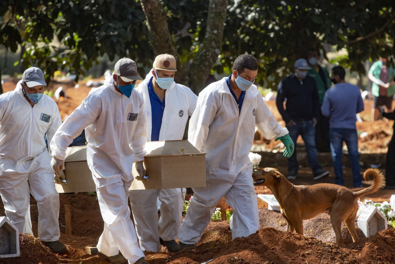 Cemetery workers in protective clothing carry the coffin of a COVID19 victim in Sao Paulo.