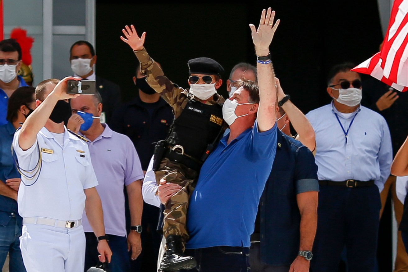 Brazilian President Jair Bolsonaro (in blue) at an anti-lockdown rally in Brasilia on Monday (Australian time).