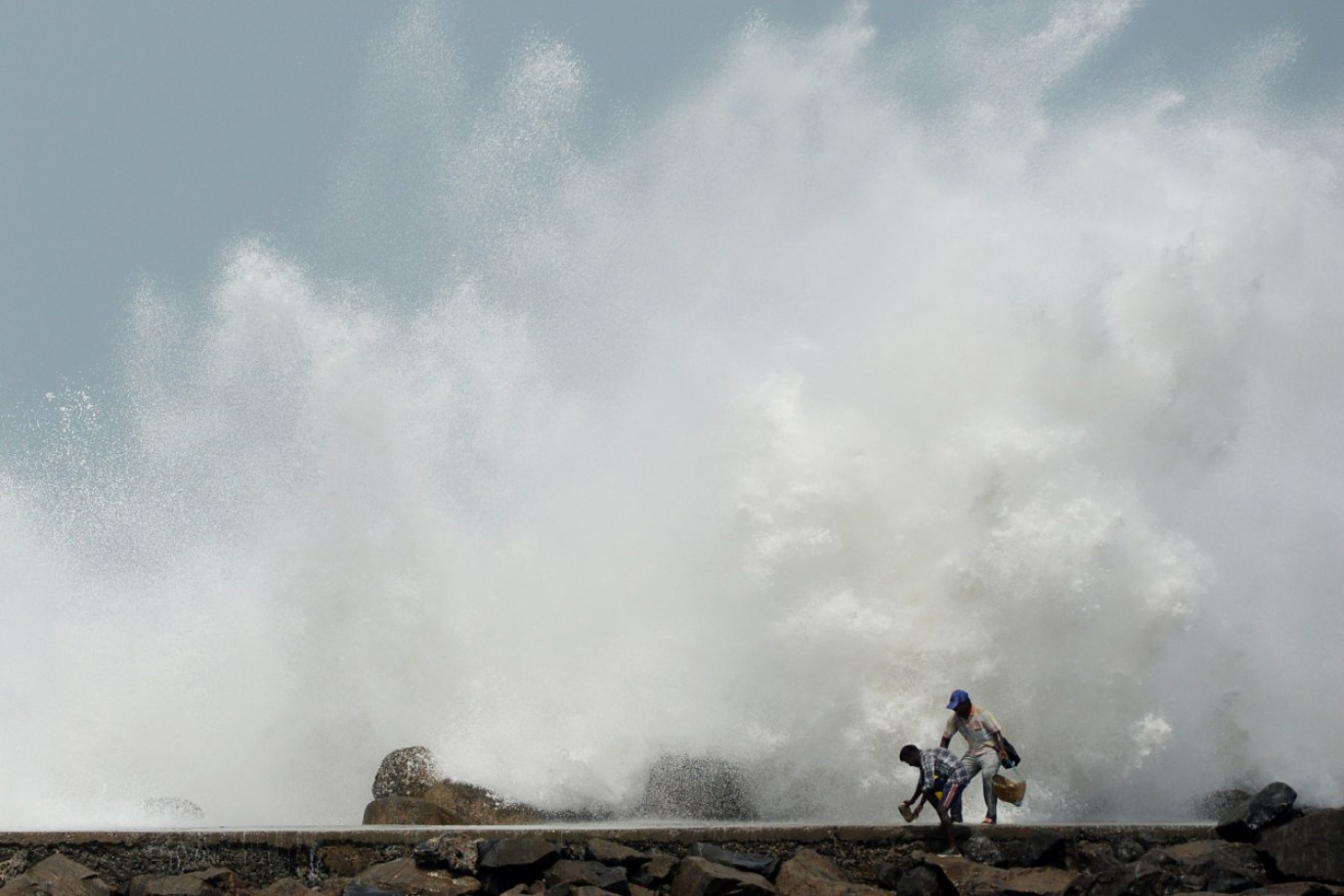 Two men on a breakwater at Kasimedu fishing harbour in Chennai as cyclone Amphan nears India and Bangladesh.