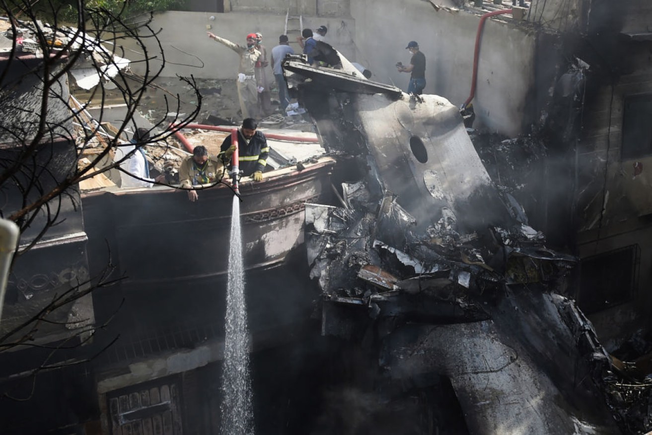 Firefighters spray the wreckage of a Pakistan International Airlines aircraft after it crashed at a residential area in Karachi.