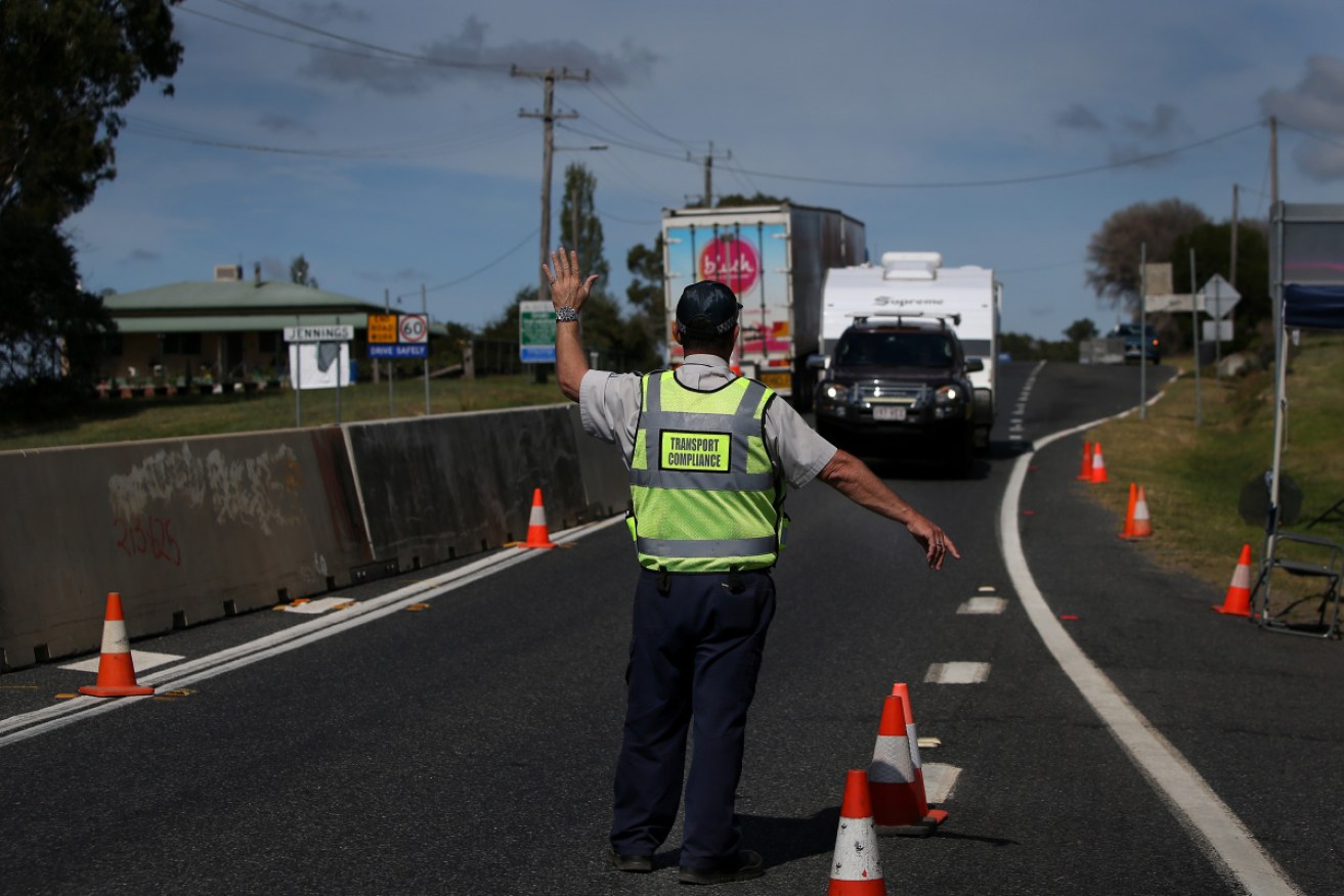 A driver is stopped on the Queensland border in April. The state's borders remain shut.