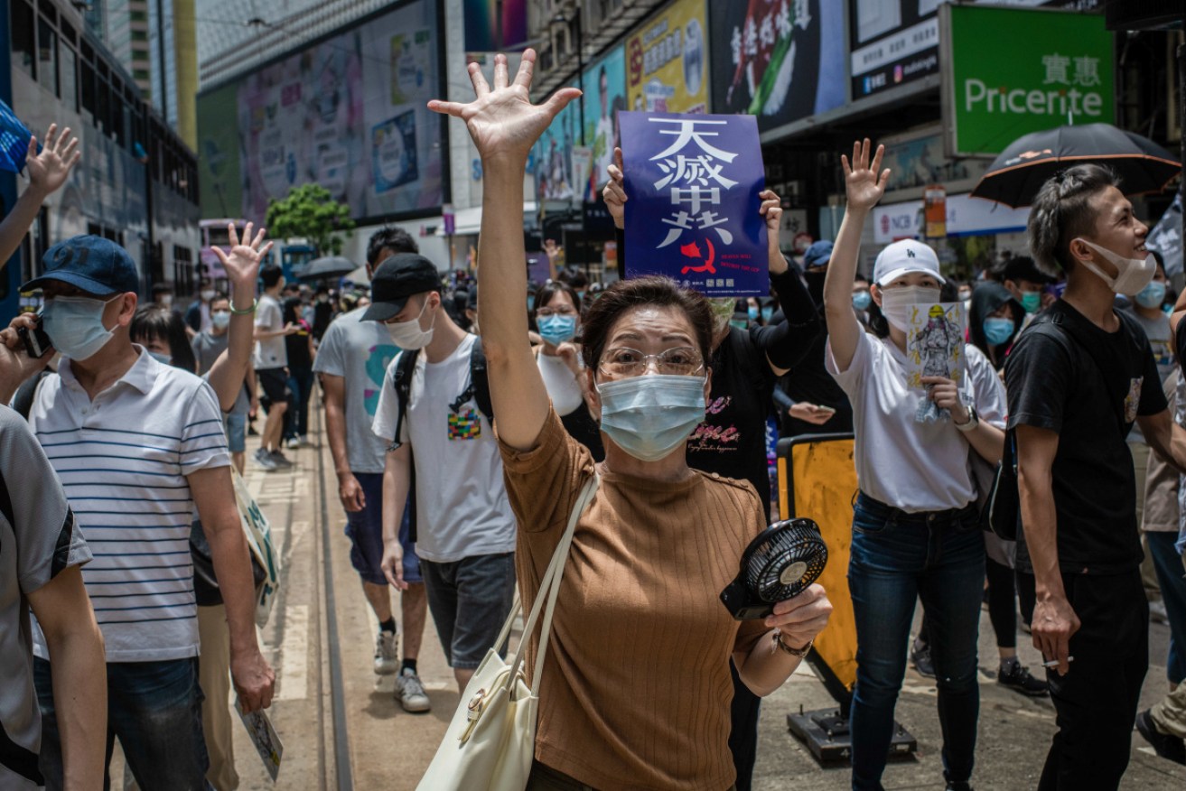 Hong Kong protesters gesture the five demands sign during demonstrations against the draft bill.