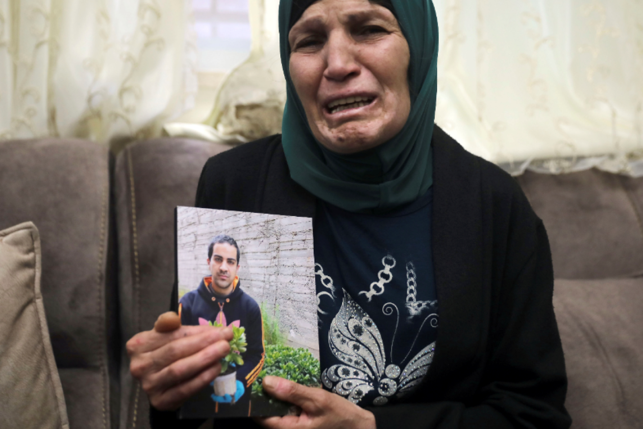 Iyad Halak's sobbing mum Rana holds a picture of her slain son.
