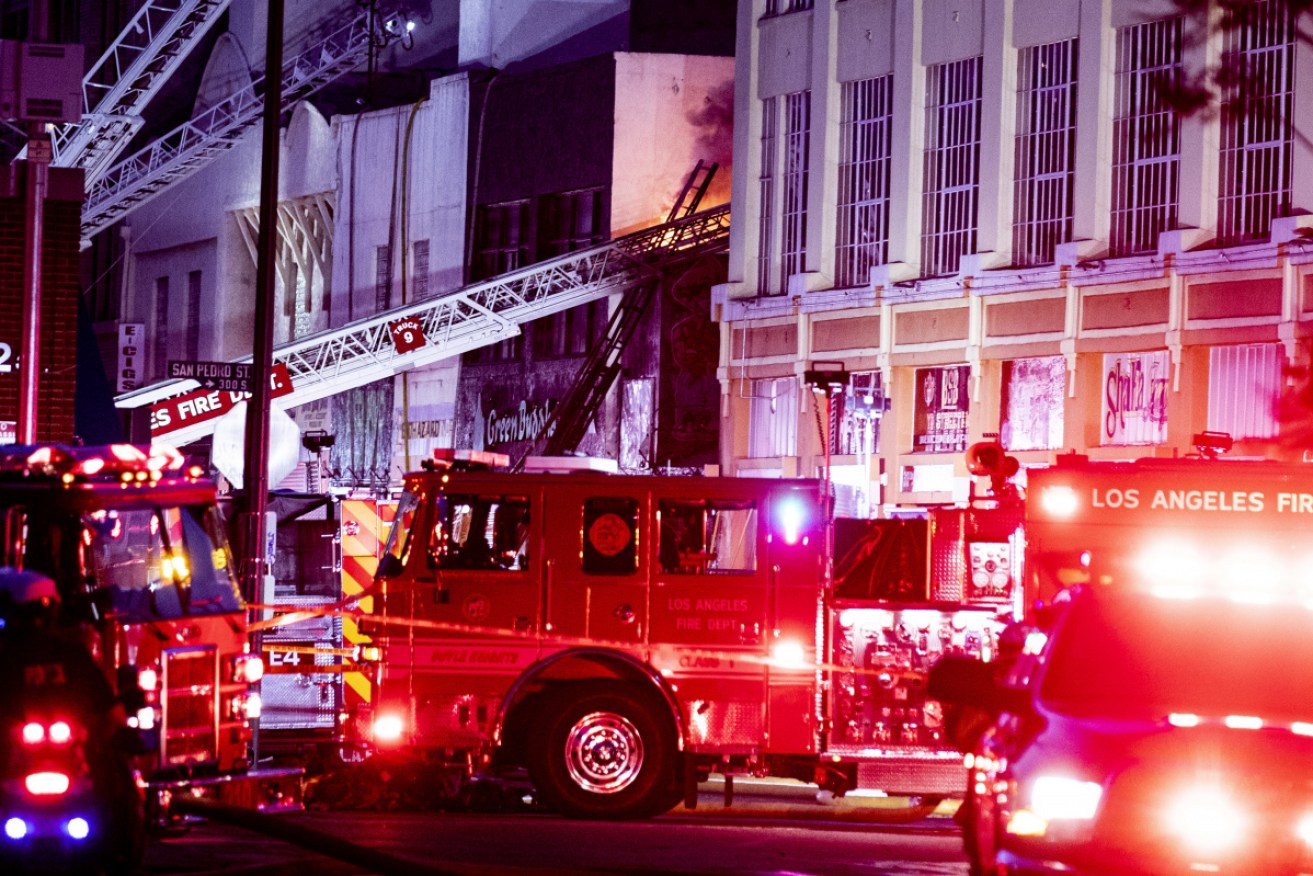 Firefighters work at the scene of an explosion in downtown Los Angeles on Saturday night, local time.