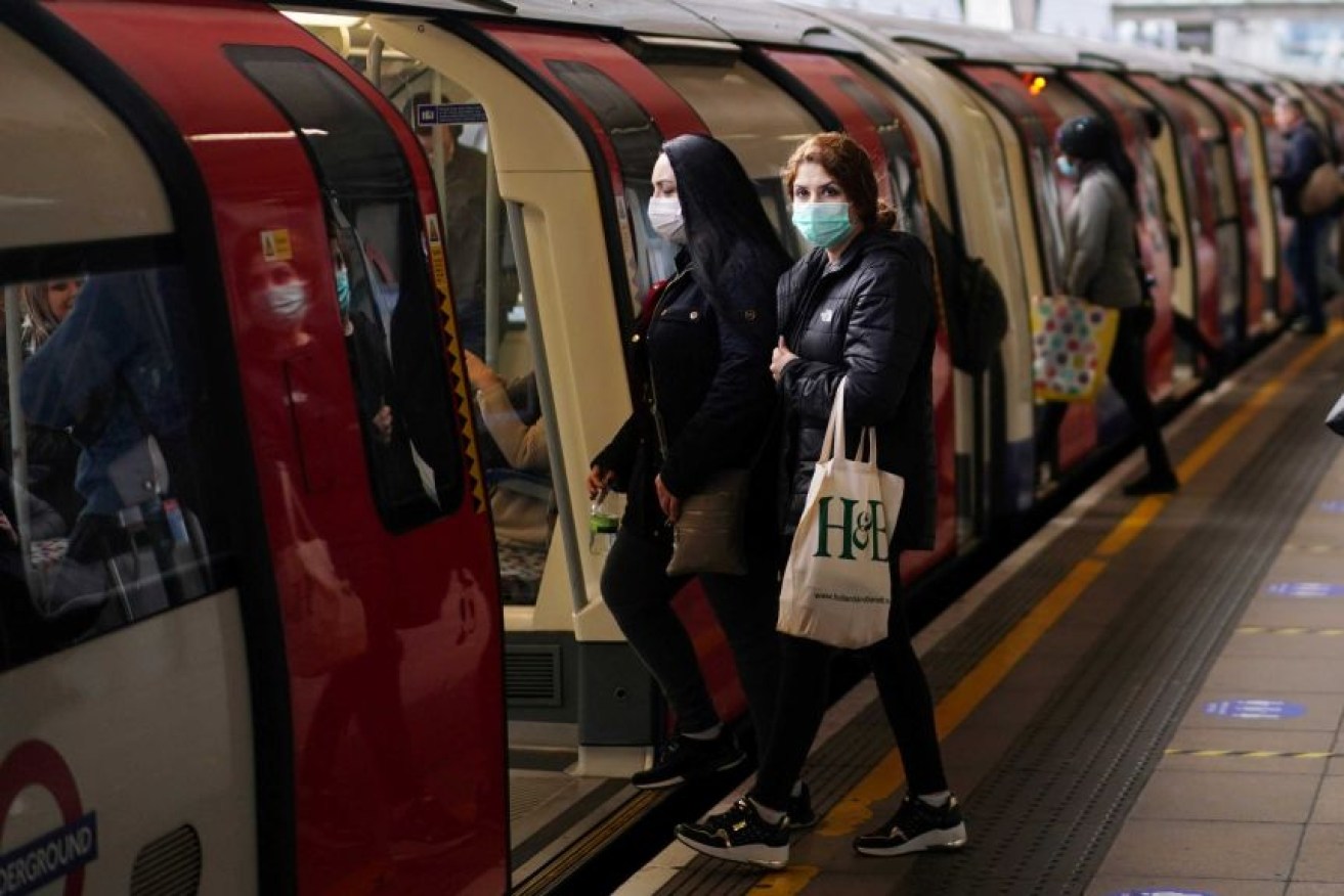Commuters get on the London Tube after coronavirus restrictions were eased.