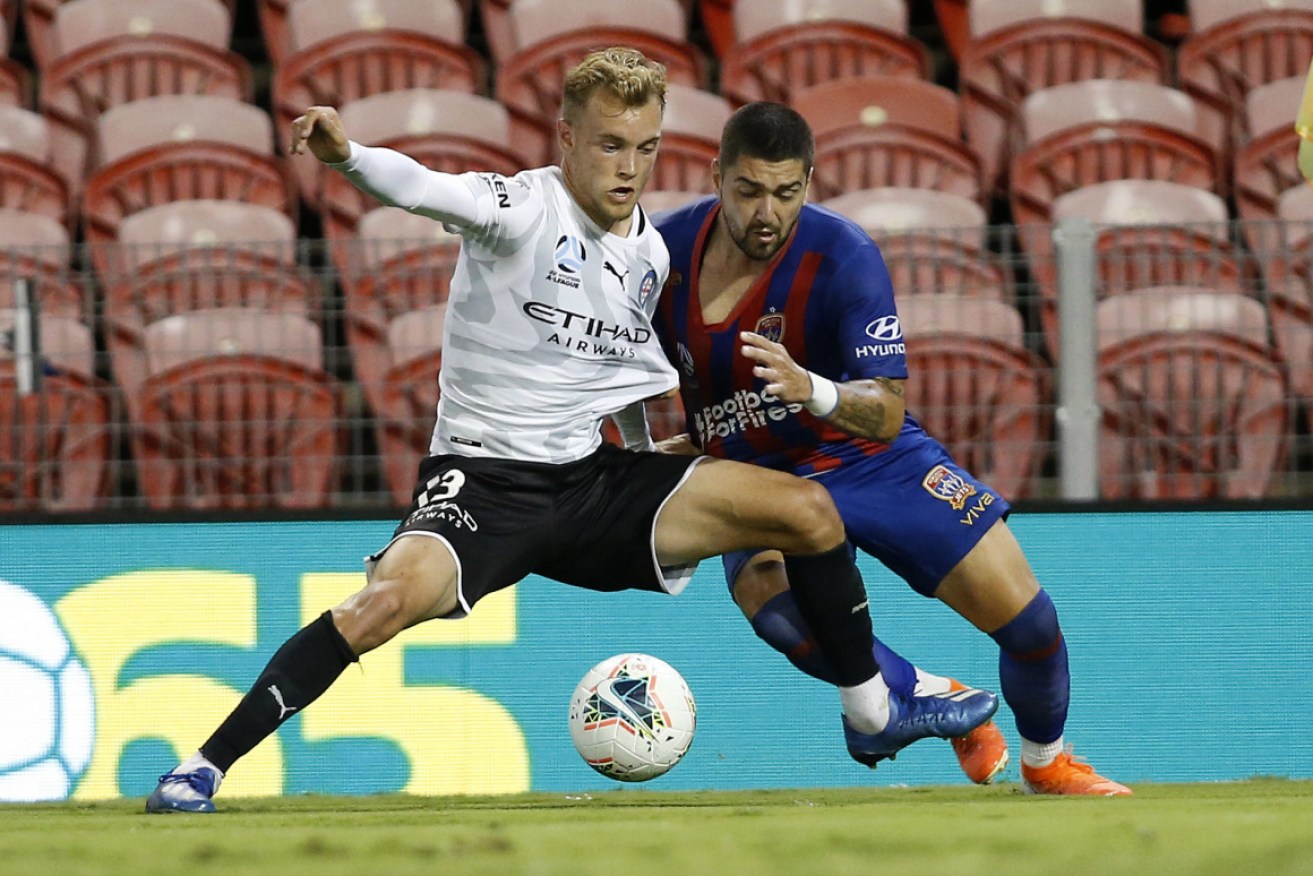 Melbourne City's Nathaniel Atkinson and Newcastle's Dimi Petratos in A-League action on March 23.