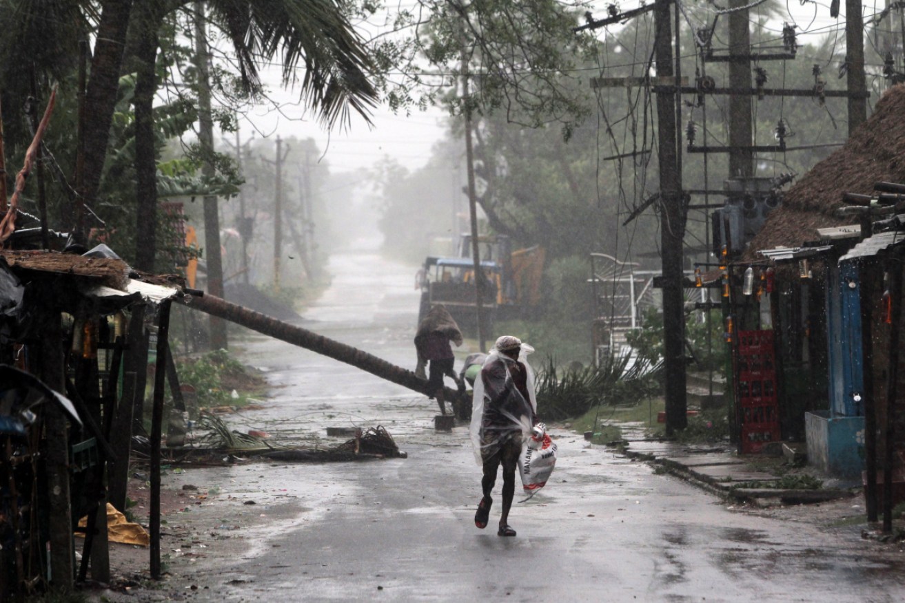 A man walks in heavy rain and wind as Cyclone Amphan approaches the Odisha coast, at Paradeep, India on Wednesday.