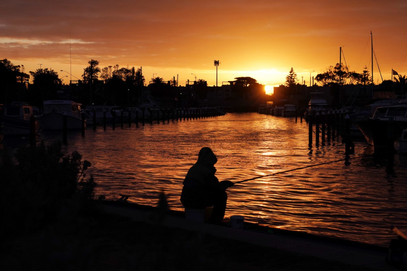Locals fish at Mordialloc harbour in Melbourne as restrictions eased on Thursday.