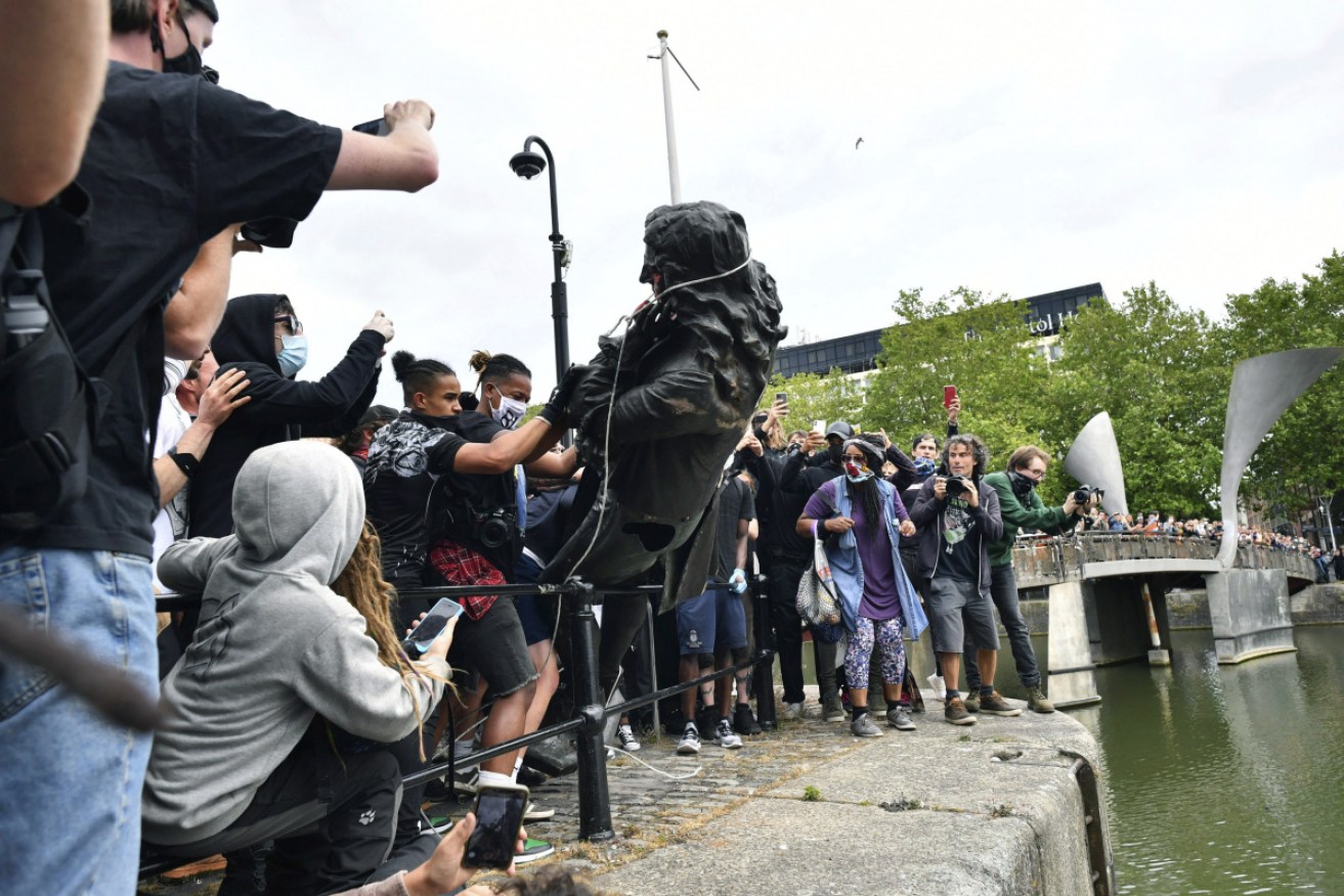 Protesters throw a statue of slave trader Edward Colston into the Bristol harbour, during a Black Lives Matter protest rally.