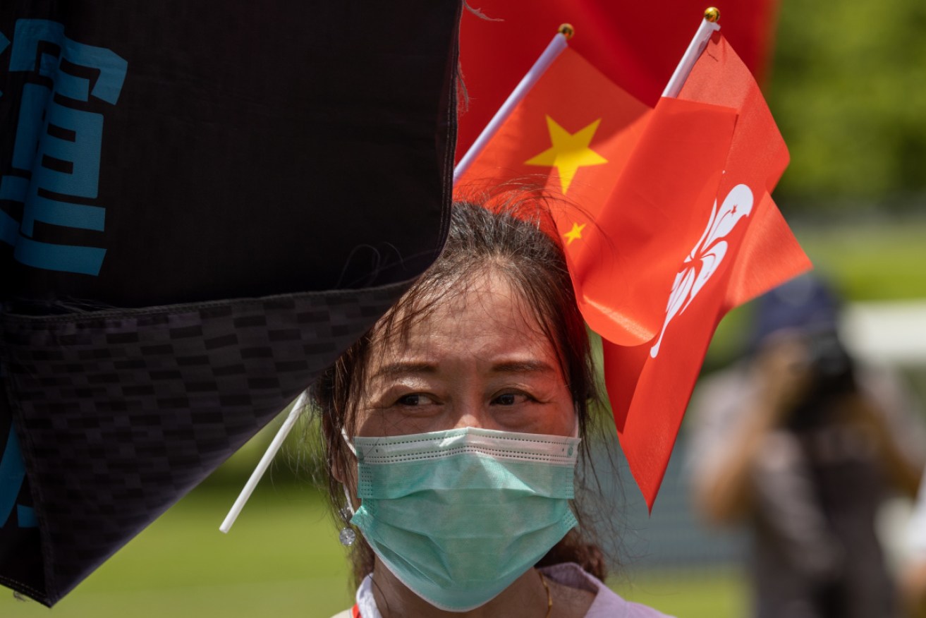 A pro-China supporter displays Chinese and Hong Kong flags during a rally in Hong Kong on Tuesday.