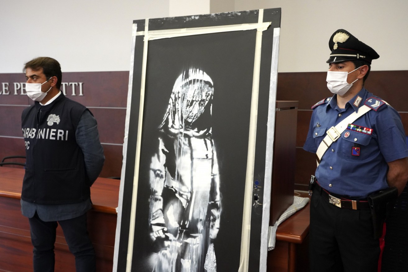 Italian authorities unveil the stolen artwork in L' Aquila, Italy on Thursday.