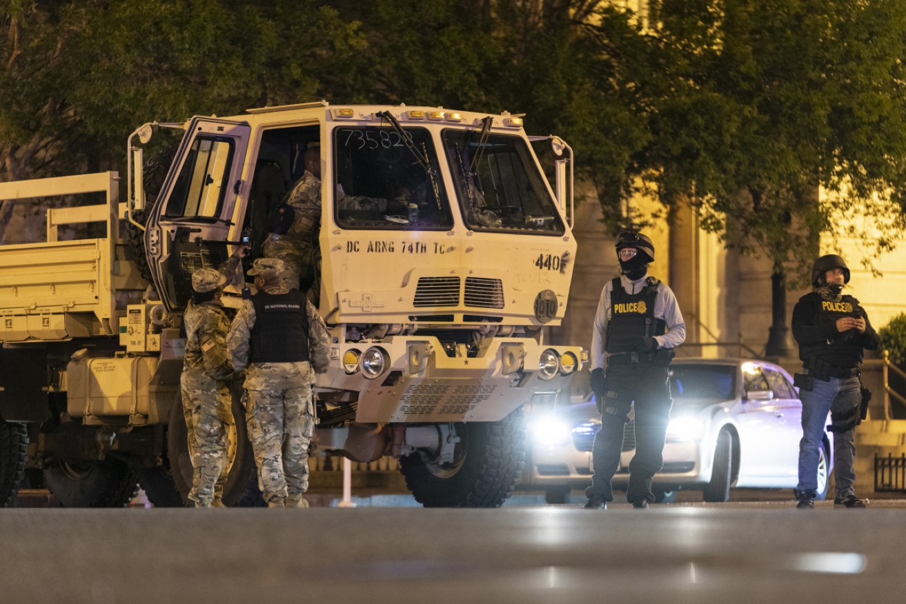 Members of the National Guard block an intersection after demonstrations in Washington DC continued after curfew.