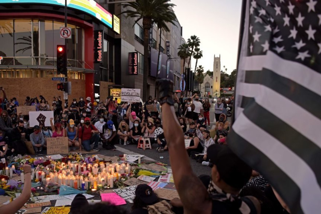 People gather around a makeshift memorial in honor of the victims of police brutality, during a demonstration against racism, in Hollywood