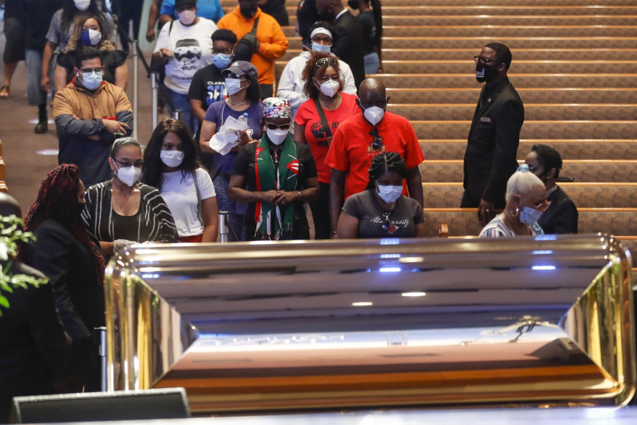 Mourners wait to visit the casket of George Floyd during a public visitation at the Fountain of Praise church on Monday local time.