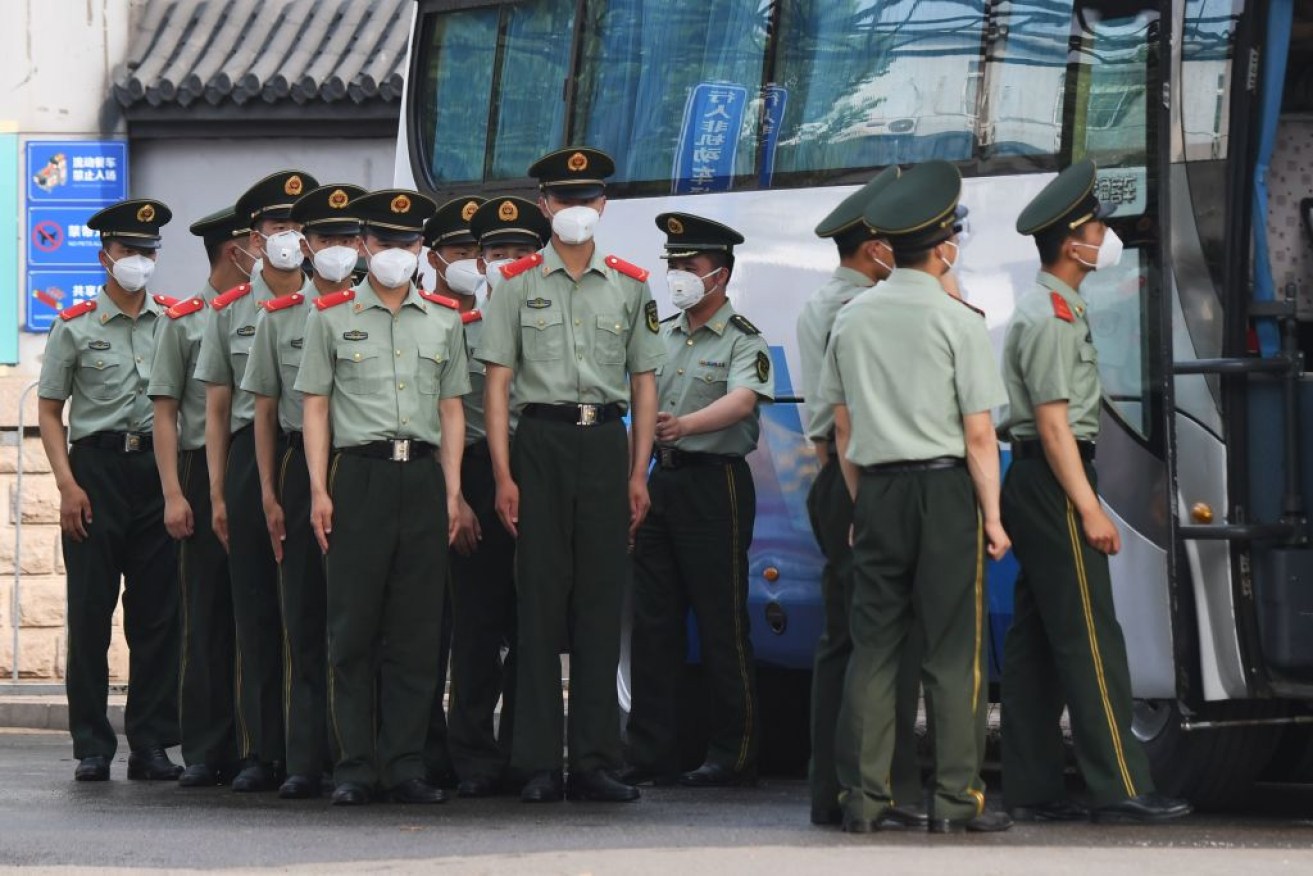 Chinese paramilitary police prepare to guard entrances to the closed Xinfadi market in Beijing.