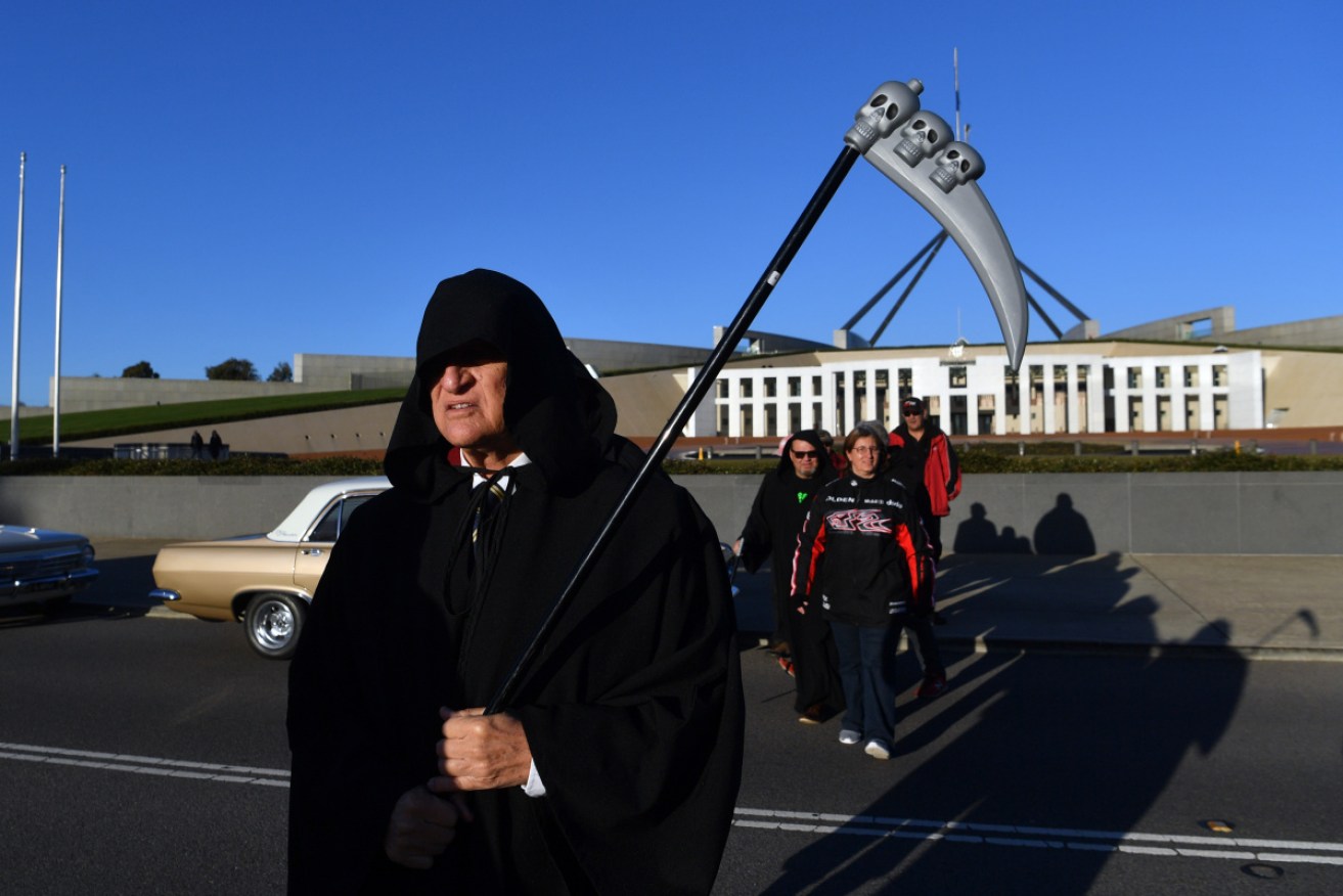 Bob Katter, as the Grim Reaper, with supporters and classic Holdens at Parliament House on Thursday.