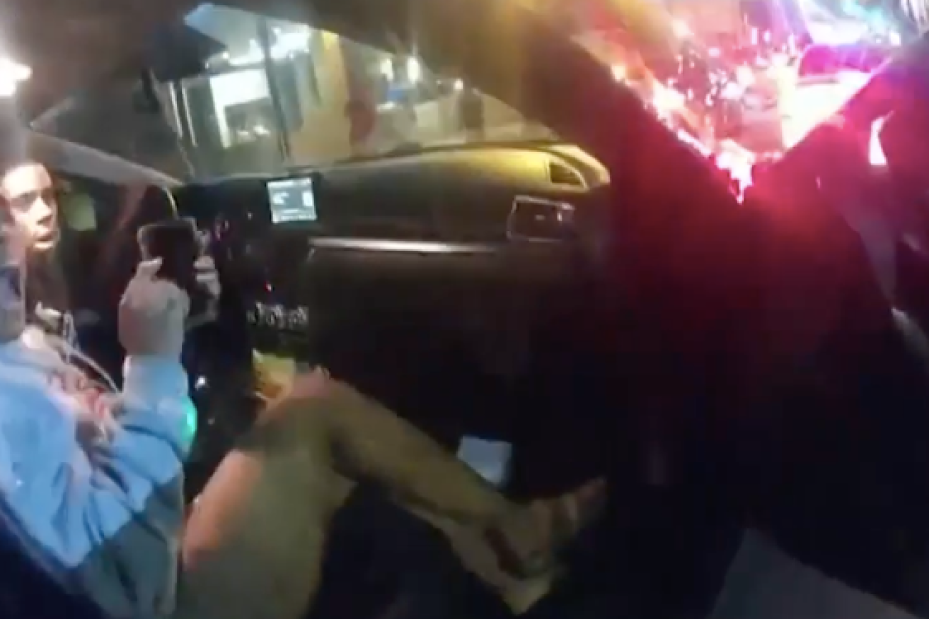 A viral video shows two young people being pulled from their car by police officers. 