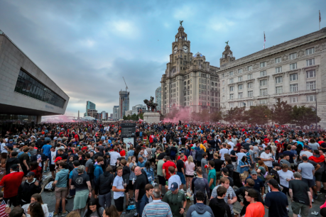 Jubilant Liverpool fans ignore COVID-19 threat