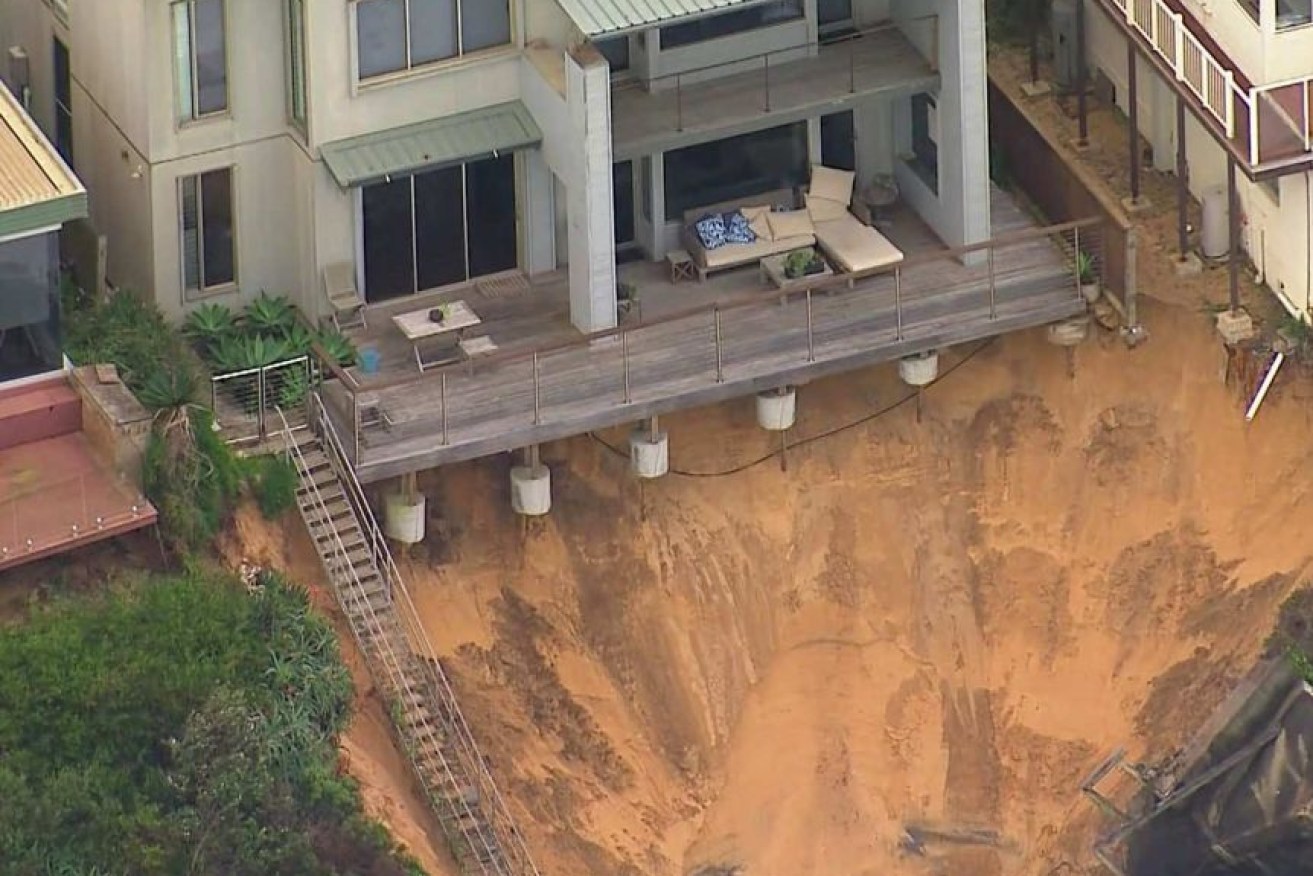 A house teeters on the edge after the erosion.