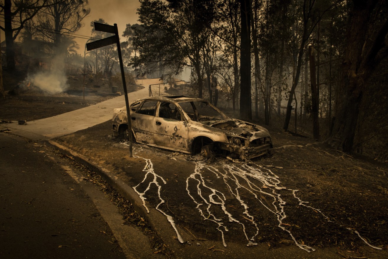 Melted metal runs from a burnt-out car after bushfires tore through Conjola Park in NSW. 