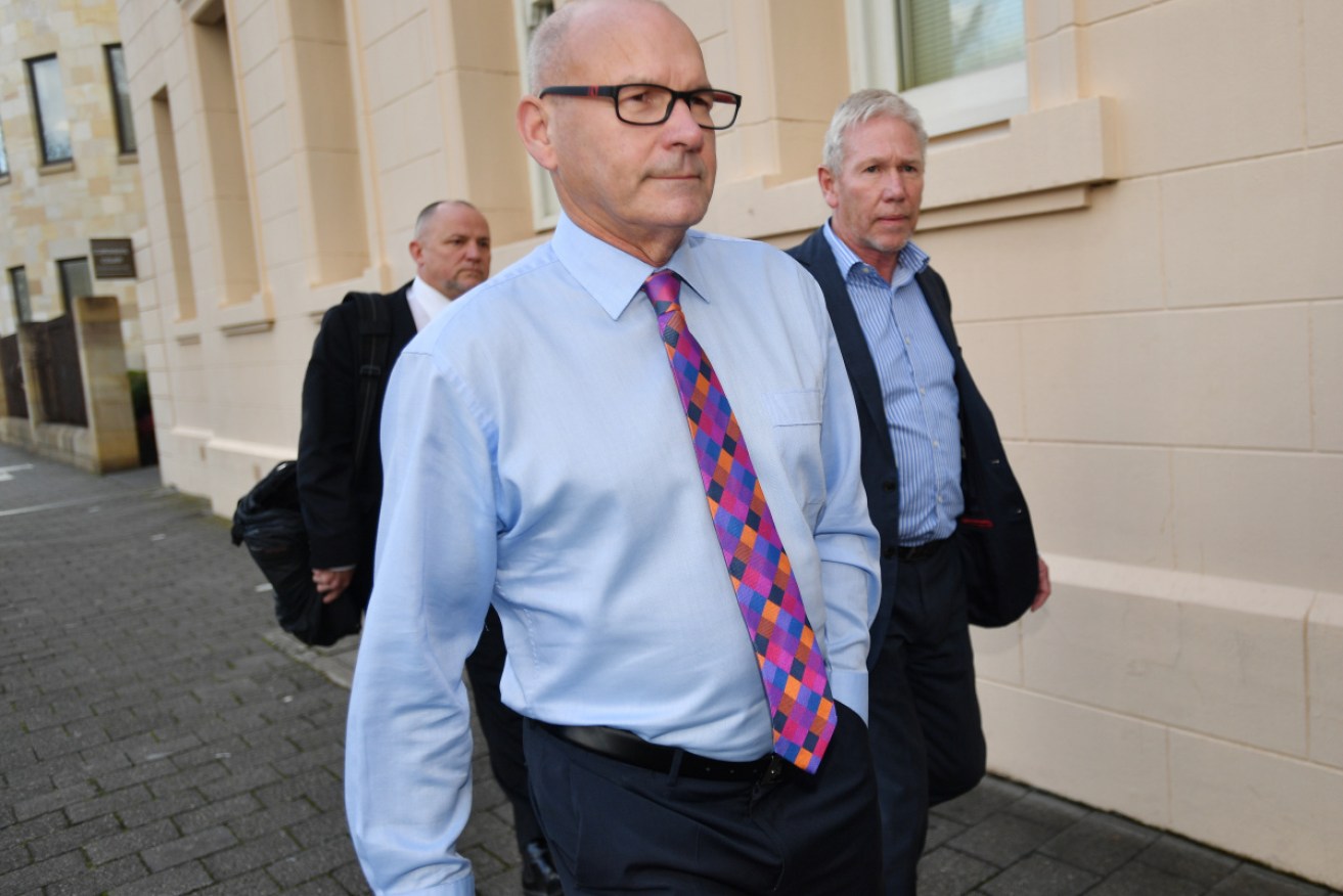 South Australian magistrate Bob Harrap leaves court after appearing on deception charges.
