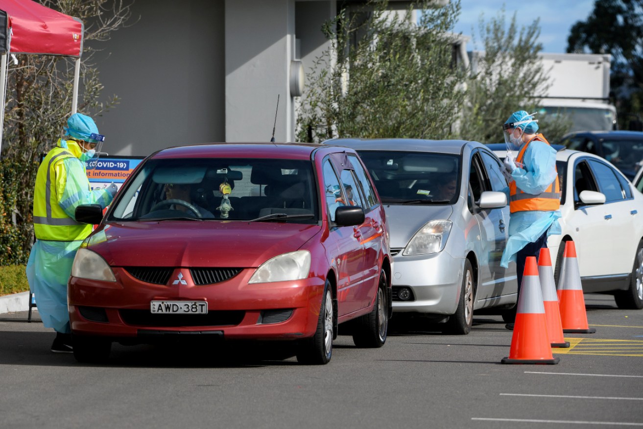 NSW Health workers  test people in their cars at the Crossroads Hotel testing centre in Sydney,