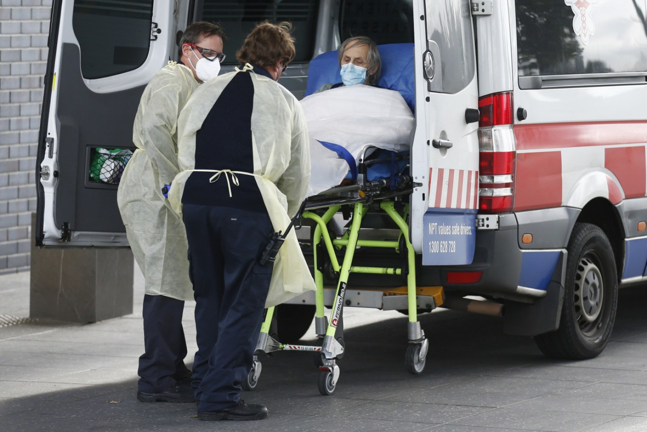 A resident is moved out of the Epping Gardens home, in Melbourne's north, where there have been more than 200 COVID infections.