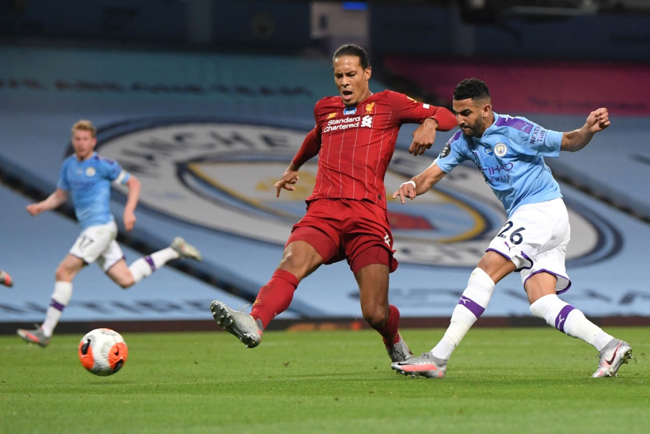 Manchester City's Riyad Mahrez is challenged by  Liverpool' Virgil van Dijk.