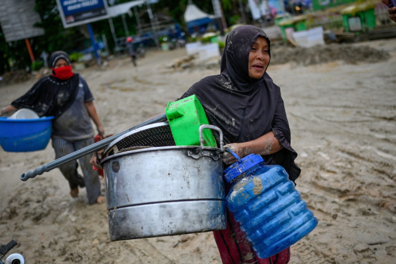 Villagers carry their belongings to evacuation camps following flash floods in South Sulawesi on Wednesday.