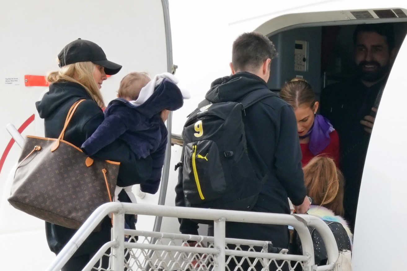 On the move: Brooke Cotchin (L) and her husband Trent take their family on the AFL charter flight to Queensland.