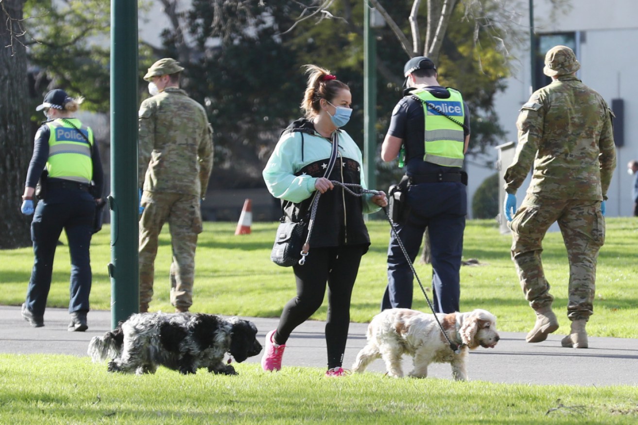 ADF personnel and Victoria Police officers patrol Fitzroy Gardens in Melbourne.