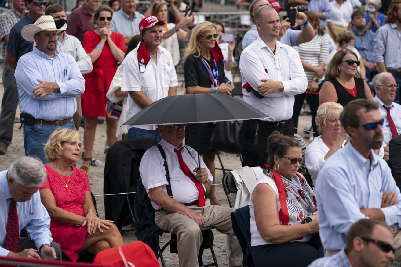 Trump supporters listen as he delivers remarks on the ‘Farmers to Families Food Box Program’ during one of four unscheduled appearances ahead of Monday night's convention.