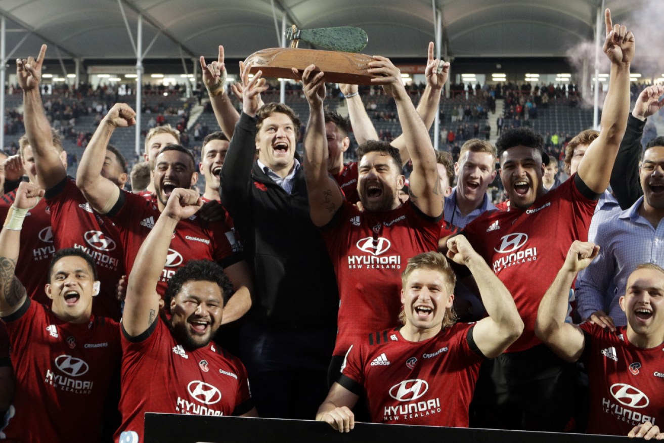 Crusaders Codie Taylor and injured teammate Scott Barrett hold aloft the Super Rugby Aotearoa trophy in Christchurch on Sunday.