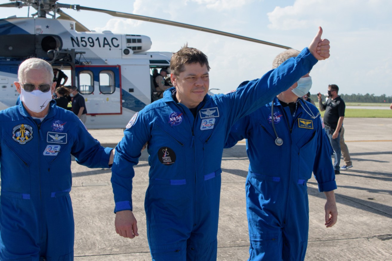 NASA astronaut Robert Behnken gives a thumbs up as he boards a plane at Naval Air Station Pensacola.