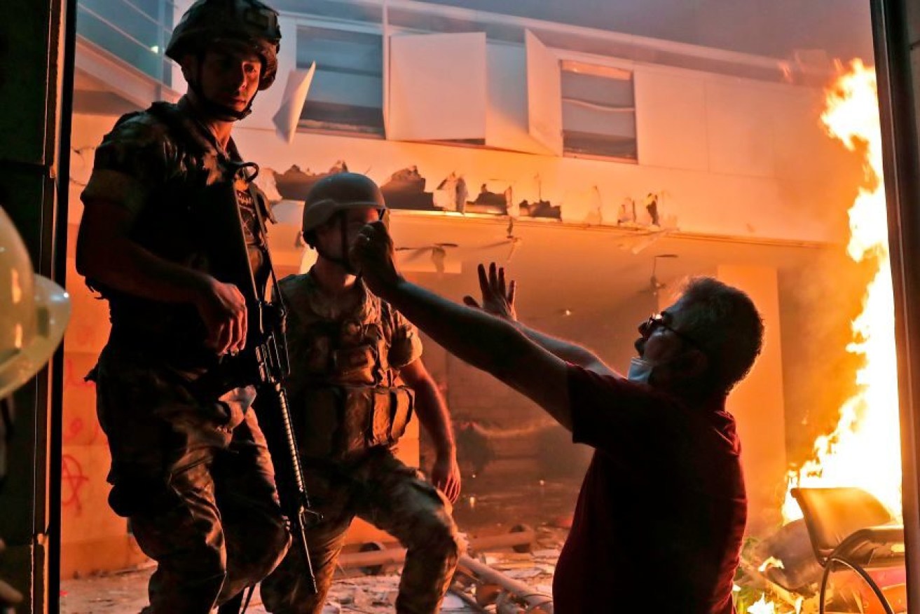 A Lebanese protester and soldiers at the headquarters of the Lebanese association of banks in downtown Beirut.