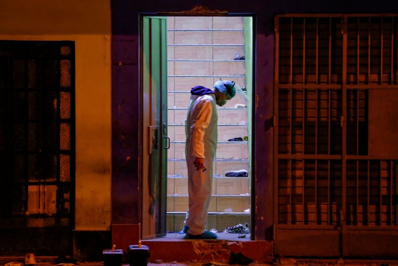 A police investigator  at the site where at least 13 people suffocated in a stampede in Peru. <i>Photo: Getty</i>.